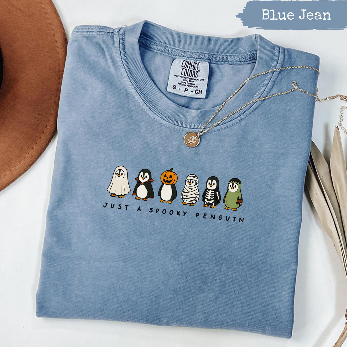 Blue t-shirt with "JUST A SPOOKY PENGUIN" and dressed-up penguins.