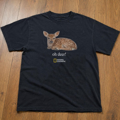 May include: A black short-sleeved t-shirt featuring a graphic of a brown spotted fawn lying down. Below the fawn, the text reads "oh deer!" in white, followed by the yellow and white National Geographic logo centered on the chest area.