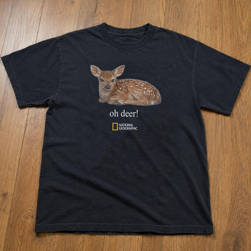 May include: A black short-sleeved t-shirt featuring a graphic of a brown spotted fawn lying down. Below the fawn, the text reads "oh deer!" in white, followed by the yellow and white National Geographic logo centered on the chest area.