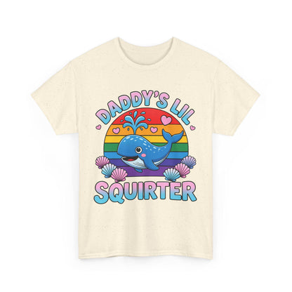 May include: A cream-colored short-sleeve t-shirt featuring a graphic of a blue whale spraying water in front of a rainbow-colored sun. The text "DADDY'S LIL SQUIRTER" is printed in blue and pink letters, surrounded by small pink hearts and seashells.