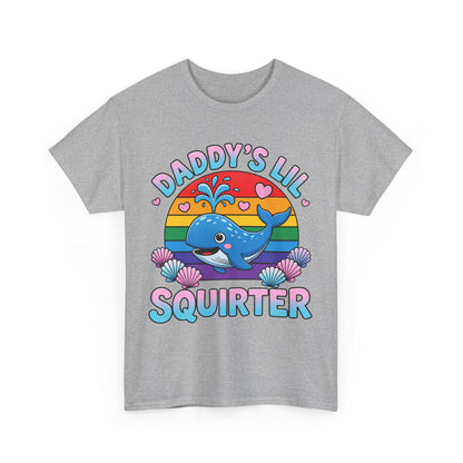 May include: A heather gray t-shirt featuring a graphic of a blue whale spraying water in front of a rainbow-colored sun. The text reads DADDY'S LIL SQUIRTER in blue and pink letters, surrounded by small pink hearts and colorful seashells at the base.