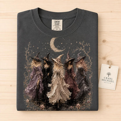 Dark gray t-shirt with illustration of five witches under a moon and stars.