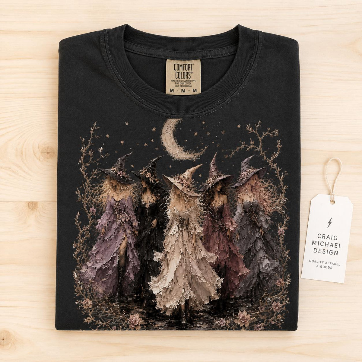 Black t-shirt with graphic of four witches, moon, and stars, Comfort Colors tag.