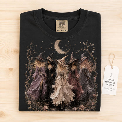 Black t-shirt with graphic of four witches, moon, and stars, Comfort Colors tag.