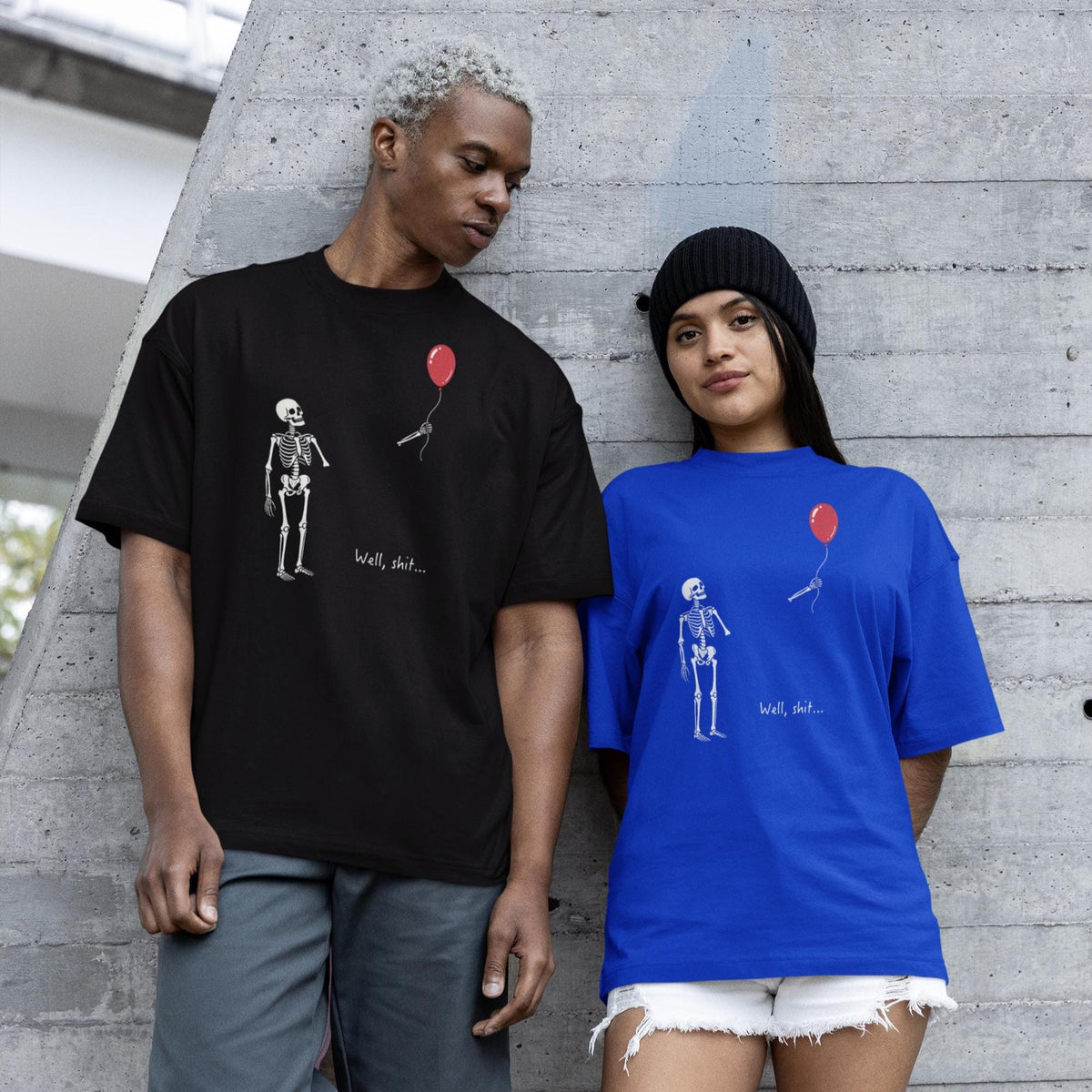 May include: A black t-shirt and a blue t-shirt, each featuring a graphic of a white skeleton looking at a red balloon floating away with a string, accompanied by the text "Well, shit..." printed in a small white font below the balloon.