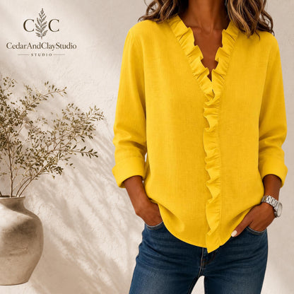 Alt Text
Woman wearing a soft ruffle V neck blouse made from lightweight breathable polyester fabric, designed as a casual long sleeve top with a loose boho fit, featuring elegant ruffle detailing along the neckline, styled with blue jeans in a minimalist indoor setting