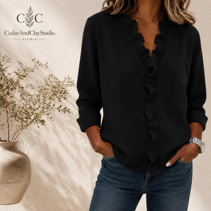 Alt Text
Woman wearing a soft ruffle V neck blouse made from lightweight breathable polyester fabric, designed as a casual long sleeve top with a loose boho fit, featuring elegant ruffle detailing along the neckline, styled with blue jeans in a minimalist indoor setting