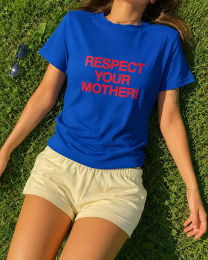 May include: A royal blue short-sleeved t-shirt featuring the text "RESPECT YOUR MOTHER!" printed in bold red capital letters across the chest, paired with plain light yellow shorts. The t-shirt has a classic crew neckline and a standard fit.