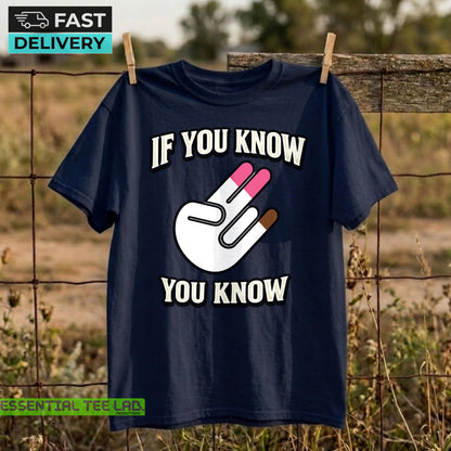 May include: A navy blue short-sleeve t-shirt featuring a white graphic of a hand making a two-finger gesture with pink tips on the fingers and a brown tip on the thumb. The text "IF YOU KNOW" is printed above and "YOU KNOW" below the graphic.