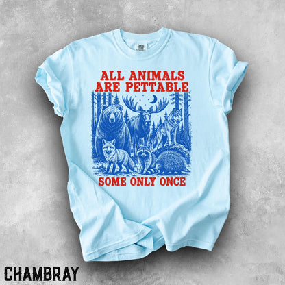 May include: A light blue t-shirt featuring a graphic print of a bear, moose, wolf, fox, raccoon, and porcupine in a forest setting. The red text reads ALL ANIMALS ARE PETTABLE at the top and SOME ONLY ONCE at the bottom of the illustration.