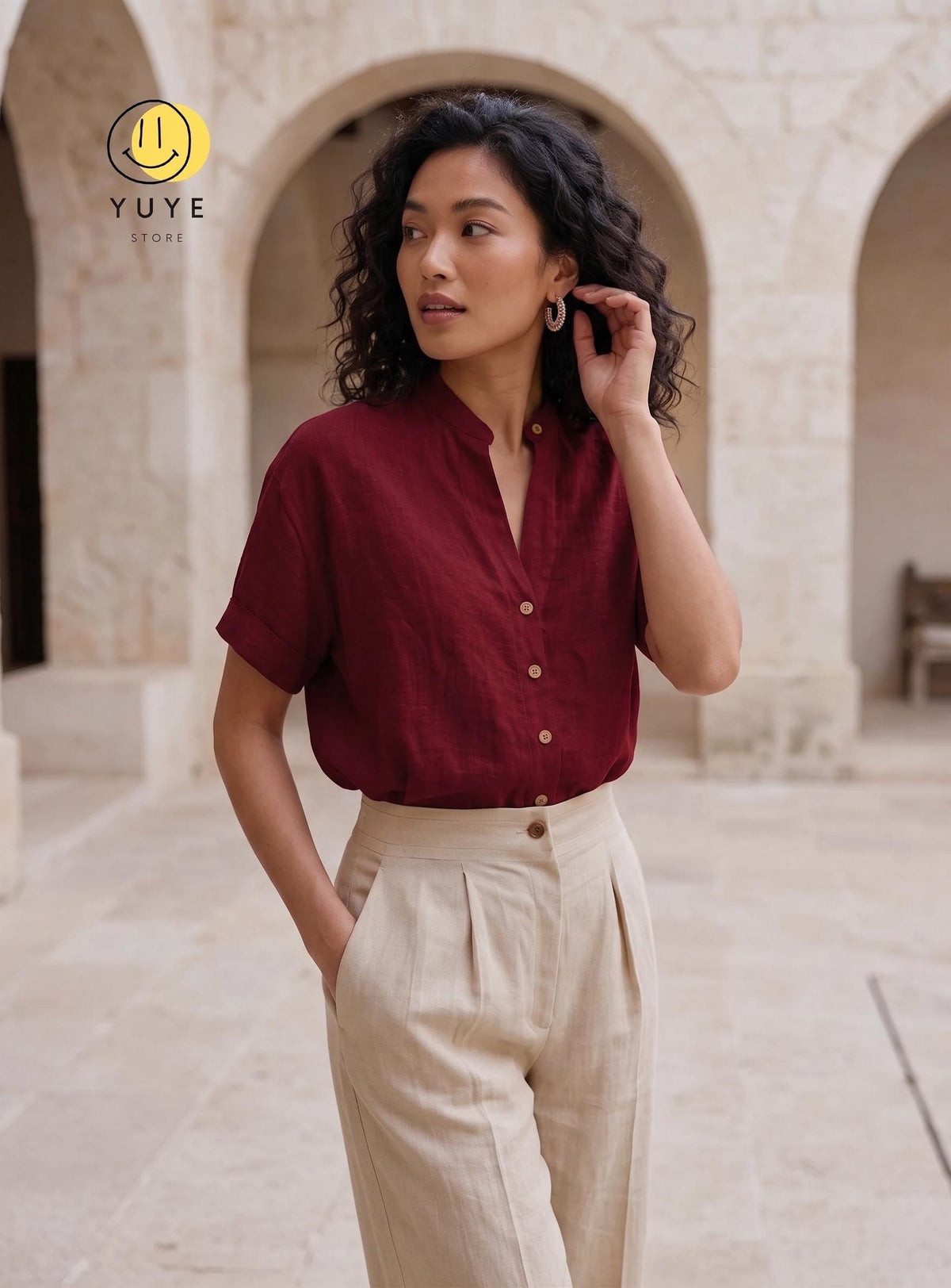 May include: A short-sleeved, button-down shirt in a deep burgundy color with a mandarin collar, paired with high-waisted, beige trousers featuring front pleats. The shirt has a visible button placket and cuffed sleeves. The YUYE STORE logo is visible.