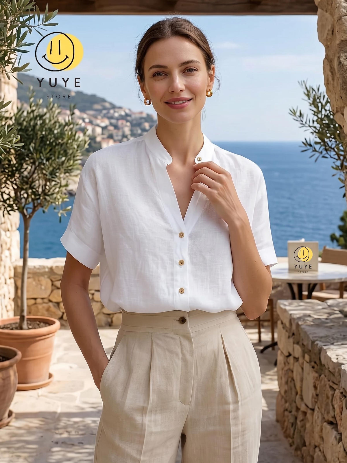 May include: A white short-sleeved button-down shirt with a mandarin collar and light brown buttons, paired with high-waisted beige trousers featuring front pleats. The shirt has a relaxed fit and cuffed sleeves, while the trousers have a button closure.