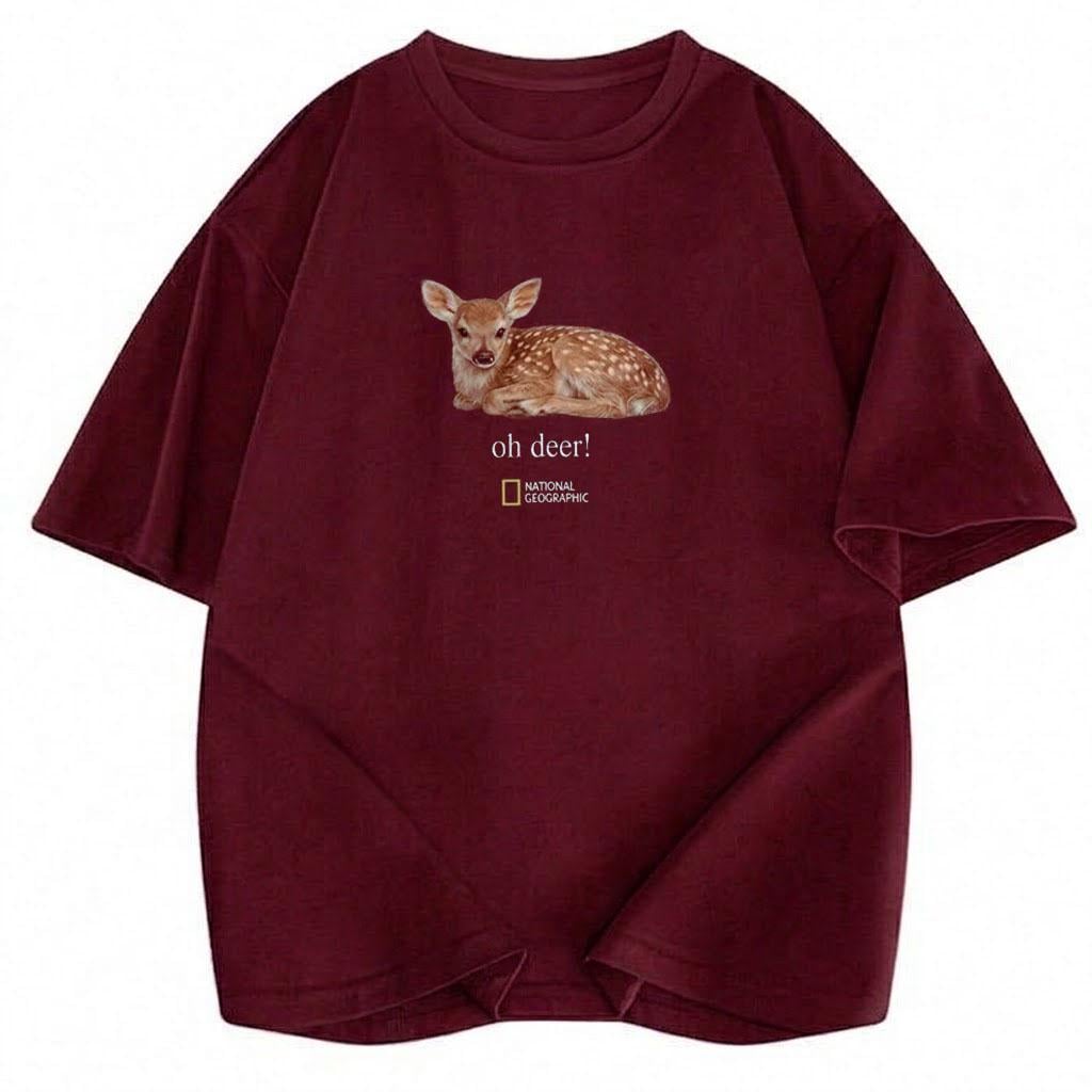 May include: A maroon short-sleeved t-shirt featuring a graphic of a spotted fawn lying down. Below the fawn, the text reads "oh deer!" followed by the National Geographic logo. The shirt has a crew neckline and a standard fit design.
