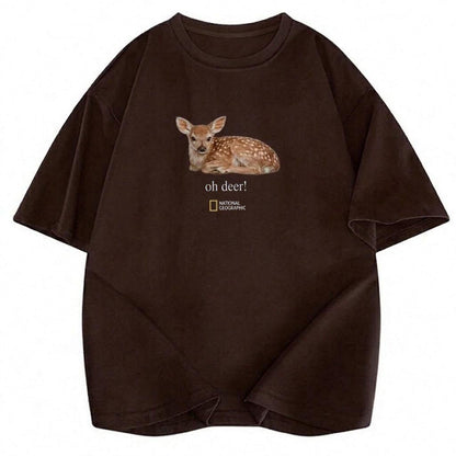 May include: A dark brown short-sleeved t-shirt featuring a graphic of a fawn lying down. Below the fawn, the text reads "oh deer!" followed by the National Geographic logo. The shirt has a crew neckline and a relaxed fit with dropped shoulders.