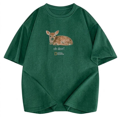 May include: A dark green short-sleeve t-shirt featuring a graphic of a fawn lying down. Below the fawn, the text reads "oh deer!" followed by the National Geographic logo. The shirt has a crew neckline and a relaxed, loose-fitting silhouette.