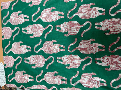 May include: A green fabric featuring a repeating pattern of stylized tigers in a light red color. Each tiger is depicted in a crouching position with a textured, wavy line design filling its body. The fabric has a smooth, flat appearance.