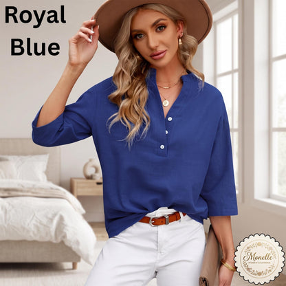 May include: A royal blue long-sleeve shirt featuring a V-neckline with a partial button placket, three white buttons, and a relaxed fit. The text Royal Blue is visible in the upper left corner, and a Monelle logo is in the bottom right corner.