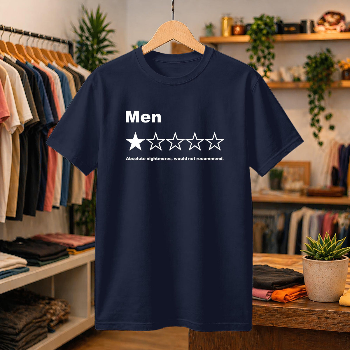May include: A navy blue short-sleeved t-shirt featuring a white graphic print. The design displays the word Men above a one-star rating out of five, with the text Absolute nightmares, would not recommend printed in white below the stars.