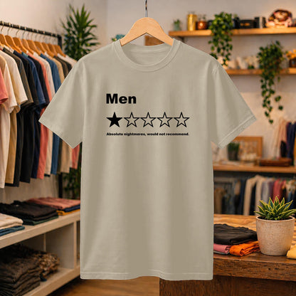 May include: A beige short-sleeved t-shirt featuring the black text 'Men' above a five-star rating graphic with one filled-in star and four empty stars, followed by the text 'Absolute nightmares, would not recommend.' printed in black.