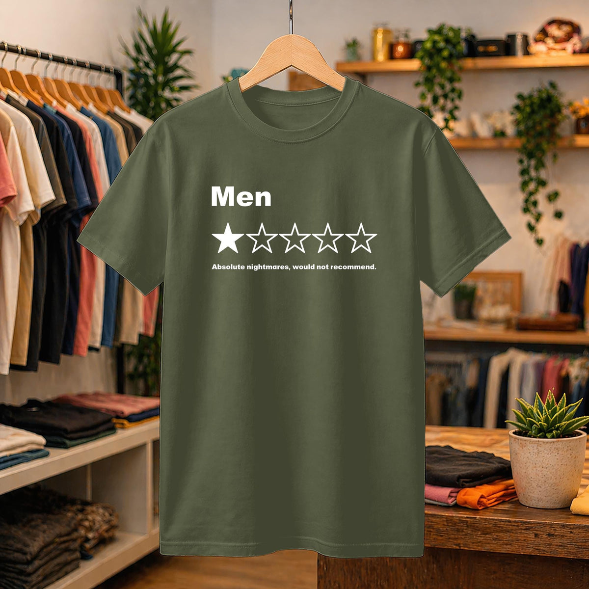 May include: An olive green short-sleeved t-shirt featuring the white text 'Men' above a single filled star and four empty stars, followed by the text 'Absolute nightmares, would not recommend.' The shirt has a crew neckline and a standard fit.