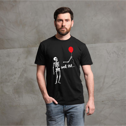 May include: A black short-sleeved t-shirt featuring a white graphic of a skeleton holding a red balloon with a detached arm floating nearby. The text "well, shit..." is printed in white script below the balloon string on the front of the shirt.