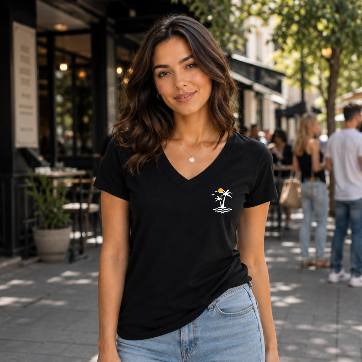 May include: A black short-sleeved t-shirt with a V-neckline. The shirt features a small graphic on the left chest area depicting two white palm trees, a yellow sun, and stylized white waves representing the ocean surface.