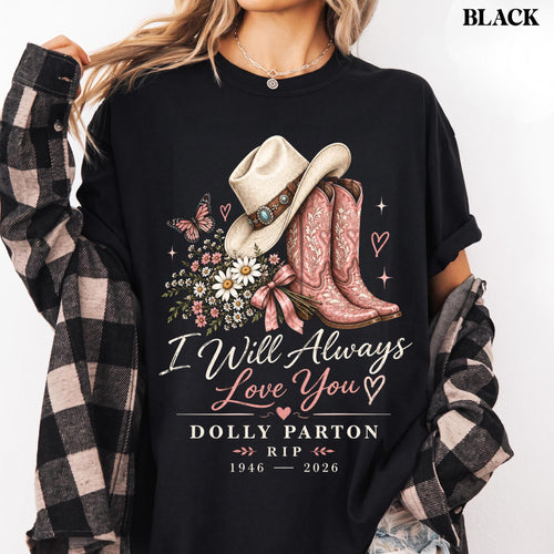 May include: A black t-shirt featuring a graphic of a cowboy hat, pink cowboy boots, a butterfly, and a bouquet of daisies. The text reads: I Will Always Love You, DOLLY PARTON, RIP, 1946-2026. The shirt is worn with a black and white plaid flannel shirt.