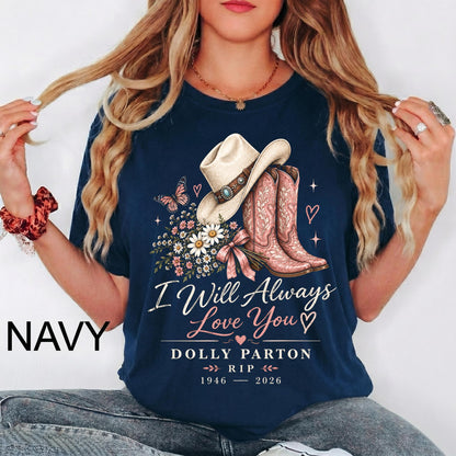 May include: A navy blue t-shirt featuring a graphic of a cowboy hat, a pair of cowboy boots, and a bouquet of flowers. The text reads: I Will Always Love You, DOLLY PARTON, 1946 - 2026. The design includes small hearts and a butterfly.