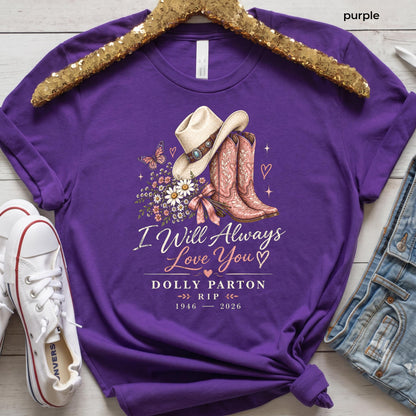 May include: A purple t-shirt featuring a graphic of a cowboy hat, a pair of cowboy boots, a butterfly, and a bouquet of flowers. The text reads: I Will Always Love You, DOLLY PARTON, RIP, 1946 - 2026. The shirt is displayed on a gold sequin hanger.