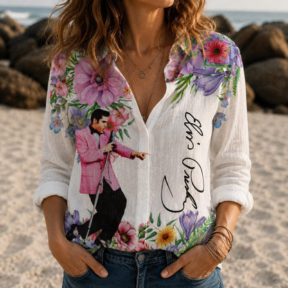 May include: A white long-sleeve button-down shirt featuring a graphic of Elvis Presley in a pink jacket and black trousers, surrounded by colorful floral patterns and the signature Elvis Presley printed in black script on the front.