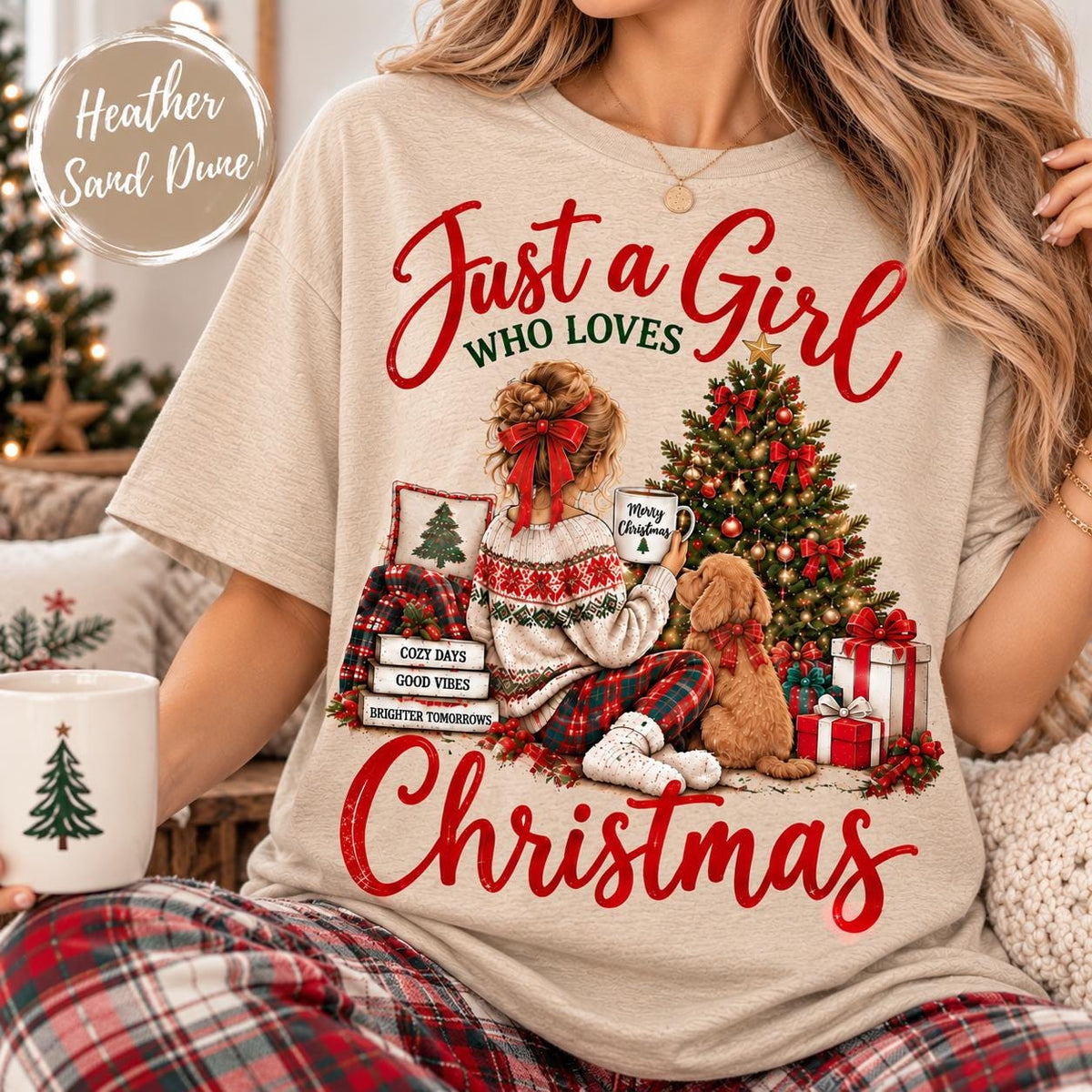 May include: A heather sand dune t-shirt featuring a graphic of a person sitting by a Christmas tree with a dog. The text reads Just a Girl WHO LOVES CHRISTMAS, COZY DAYS, GOOD VIBES, BRIGHTER TOMORROWS, and Merry Christmas on a mug.
