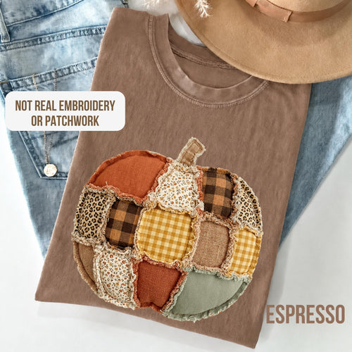 May include: An espresso-colored t-shirt featuring a printed graphic of a pumpkin composed of various fabric patterns including plaid, leopard print, and floral. The text NOT REAL EMBROIDERY OR PATCHWORK is printed in the upper left corner.