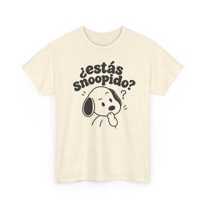 May include: A cream-colored short-sleeve t-shirt featuring a dark brown graphic of a cartoon dog with a questioning expression. Above the dog, the text reads "¿estás snoopido?" in a bold, rounded font. The fabric has a subtle speckled texture.