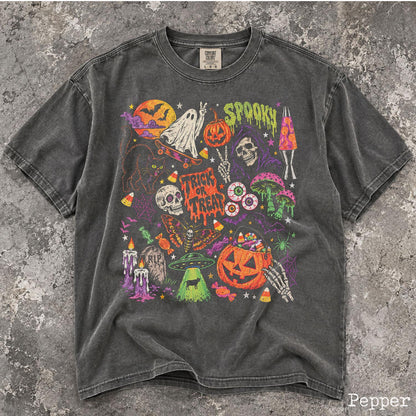 May include: A charcoal gray short-sleeve t-shirt featuring a vibrant Halloween-themed graphic print. The design includes a ghost on a skateboard, a pumpkin, a skull, a lava lamp, mushrooms, a UFO, a jack-o'-lantern bucket, and the text "SPOOKY" and "TRICK OR TREAT."