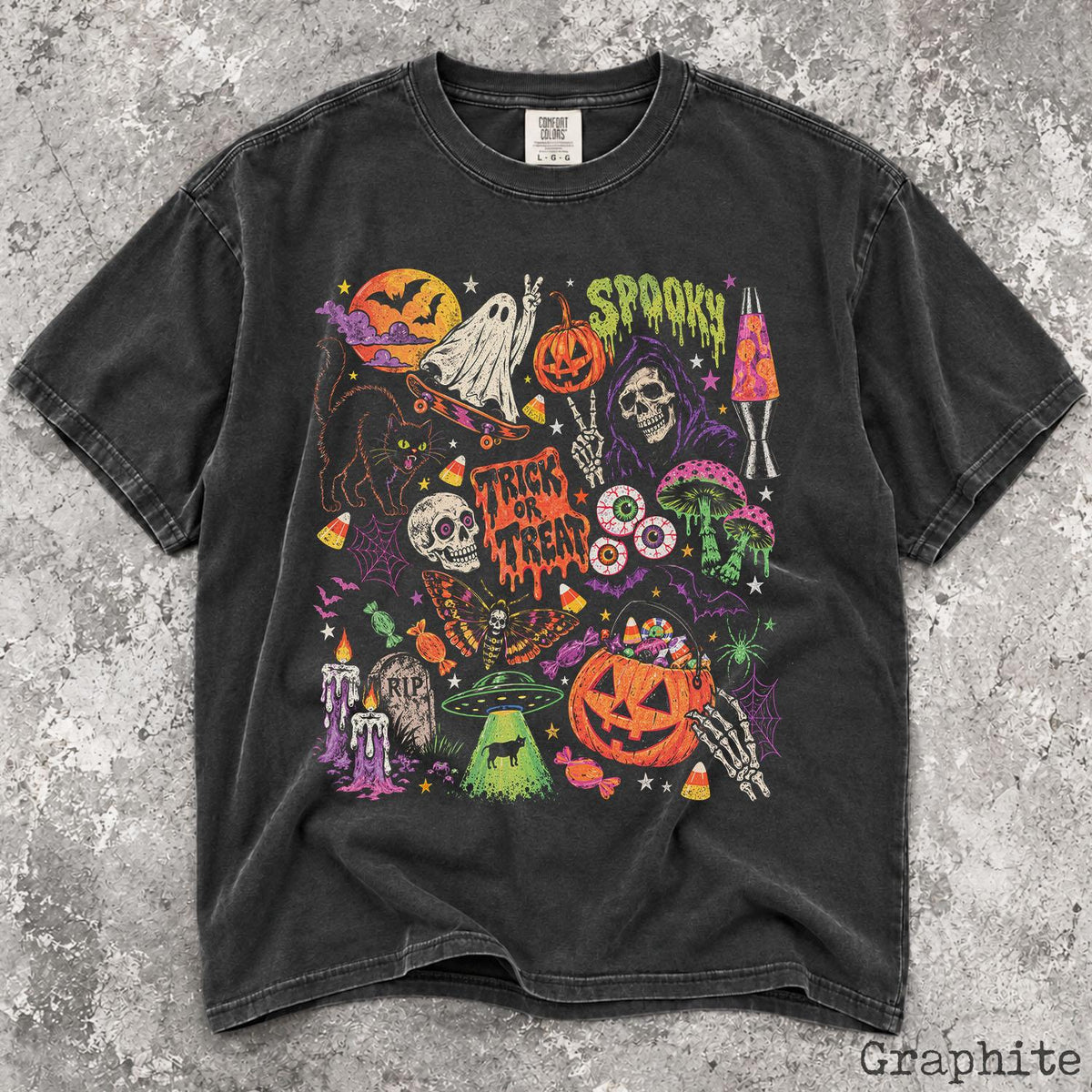 May include: A graphite-colored short-sleeve t-shirt featuring a vibrant Halloween-themed graphic print. The design includes a ghost on a skateboard, a pumpkin, a skull, a black cat, a moth, a UFO, a lava lamp, and the text "SPOOKY" and "TRICK OR TREAT".