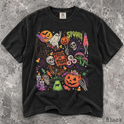 May include: A black short-sleeve t-shirt featuring a colorful graphic print of Halloween-themed illustrations including a ghost on a skateboard, a pumpkin, a skull, a black cat, a moth, a lava lamp, a UFO, and the text "SPOOKY" and "TRICK OR TREAT."