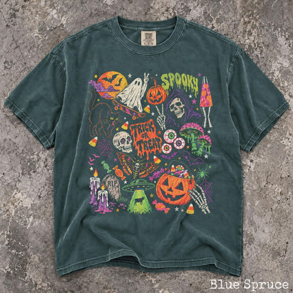 May include: A dark teal short-sleeve t-shirt featuring a colorful graphic print with Halloween-themed illustrations including a ghost on a skateboard, a skull, a pumpkin, a black cat, a UFO, mushrooms, and the text "SPOOKY" and "TRICK OR TREAT".