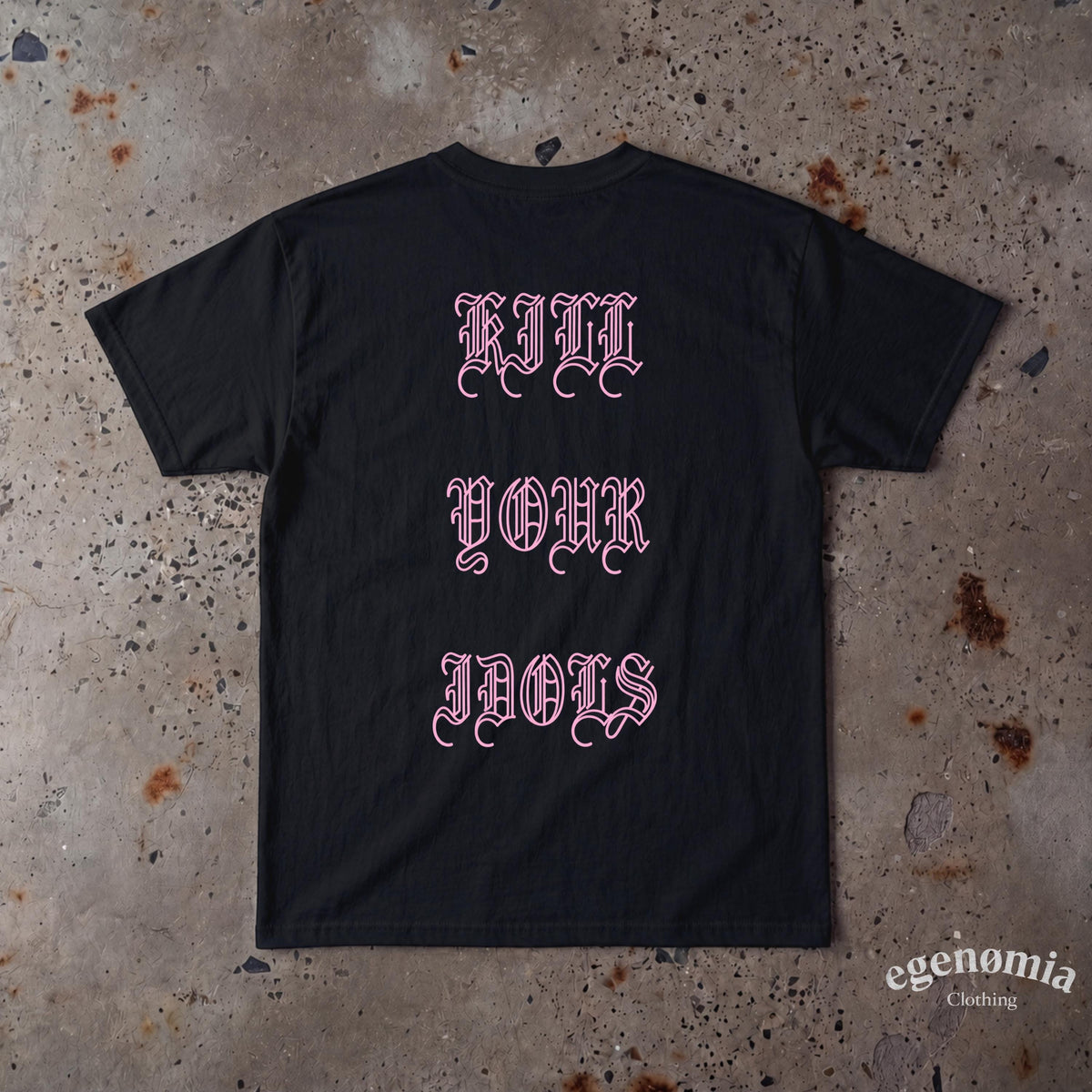 May include: A black short-sleeved t-shirt featuring the text "KILL YOUR IDOLS" printed in a light pink gothic-style font across the center. The garment has a crew neckline and a standard fit, displaying the back side of the shirt.