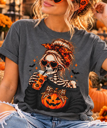 A person wearing a charcoal t-shirt printed with a graphic of a skeleton drinking pumpkin spice coffee.