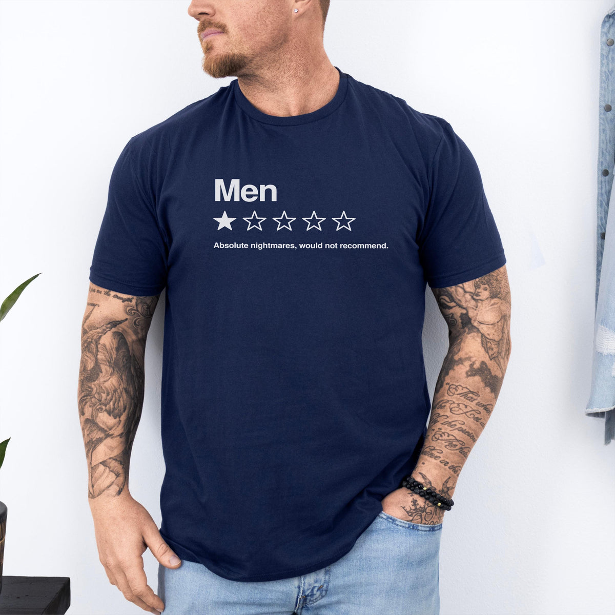 May include: A navy blue short-sleeved t-shirt featuring white text that reads "Men" above a single filled-in star and four empty star outlines, followed by the text "Absolute nightmares, would not recommend." in a clean, sans-serif font.