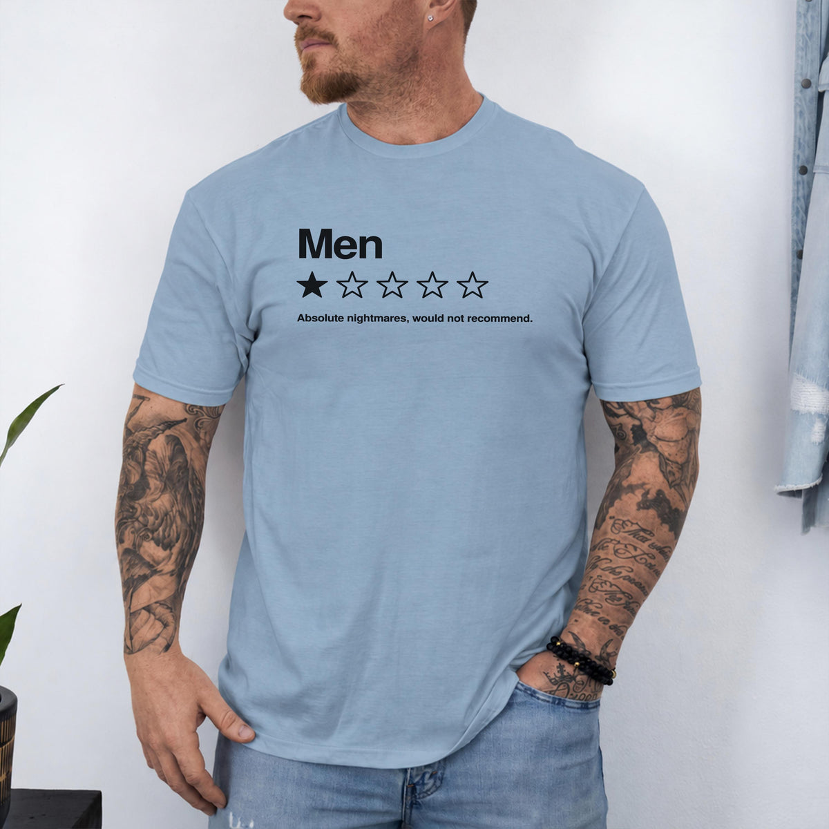May include: A light blue short-sleeved t-shirt featuring the black text "Men" above a single filled-in star and four empty stars, followed by the text "Absolute nightmares, would not recommend." The shirt has a crew neckline and a standard fit.