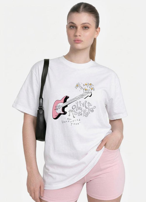 May include: A white short-sleeved t-shirt featuring a graphic of a pink electric guitar with daisies sprouting from the headstock. The text reads Olivia Rodrigo and the Unraveled Tour in a stylized font. A black shoulder bag is worn on the side.
