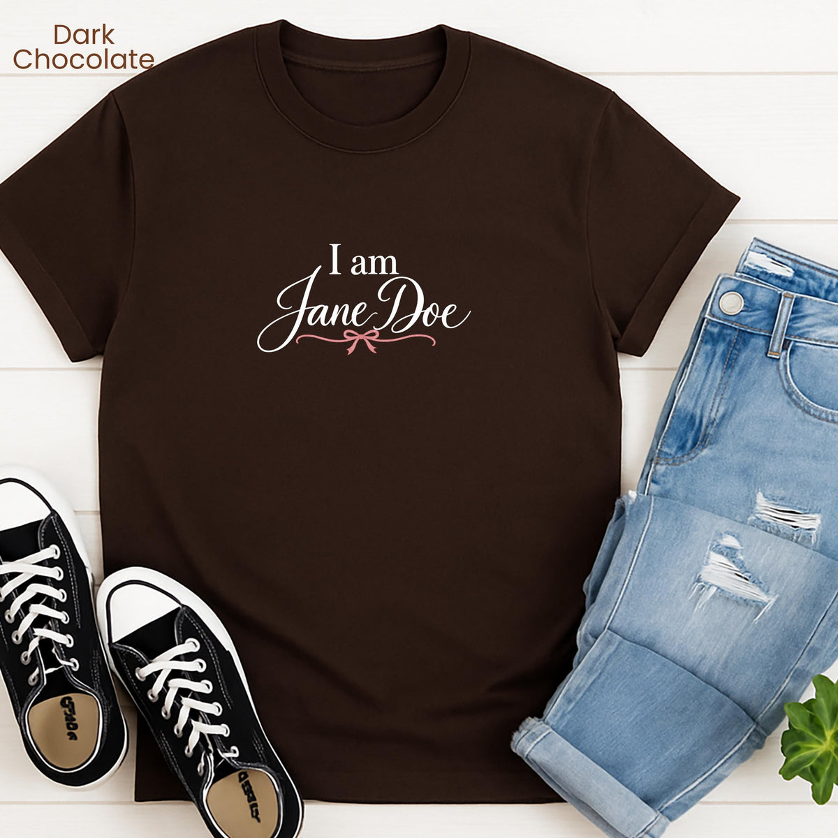 a brown t-shirt with the text "I am Jane Doe" printed on it, along with a pair of blue jeans and black and white sneakers.