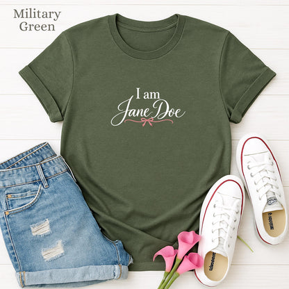 a green t-shirt with the text "I am Jane Doe" printed on it, along with a pair of blue jeans and white sneakers.