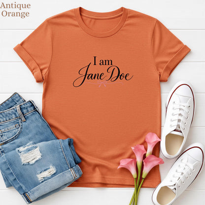 a casual outfit consisting of a red t-shirt with the text "I am Jane Doe", a pair of blue jeans, white sneakers, and pink flowers.