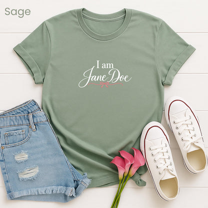 A green t-shirt with the text "I am Jane Doe" printed on it, along with a pair of denim shorts and white sneakers, all laid out on a white background.