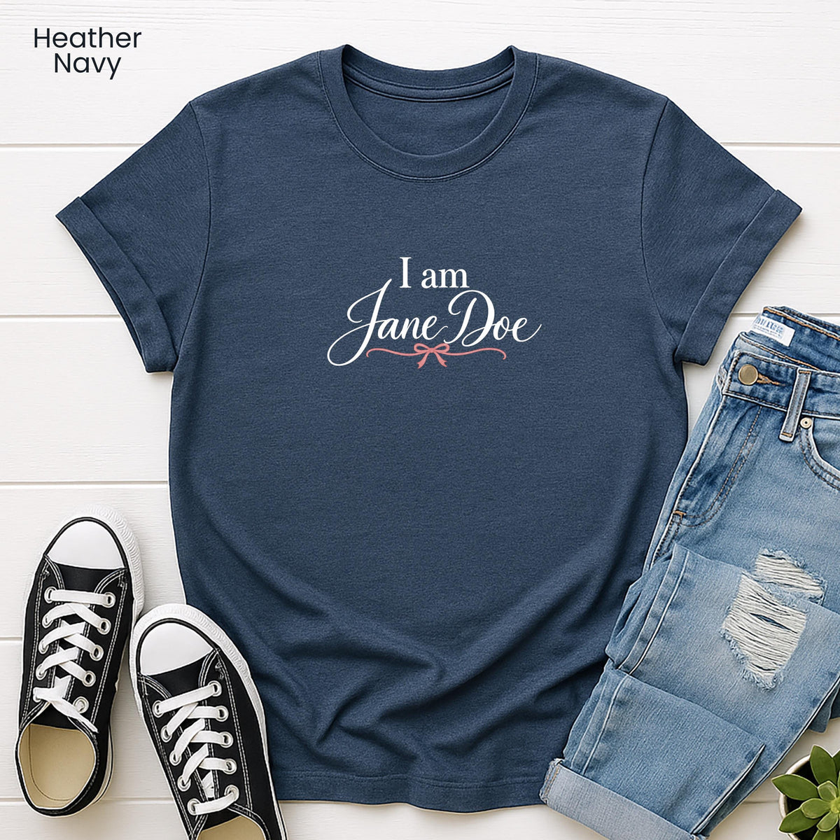 A navy blue t-shirt with the text "I am Jane Doe" printed on it, along with a pair of jeans and black and white sneakers.