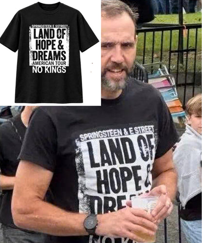 May include: A black short-sleeved t-shirt featuring a white rectangular graphic with the text "SPRINGSTEEN E STREET LAND OF HOPE & DREAMS AMERICAN TOUR NO KINGS" printed in bold black lettering across the chest area of the garment.
